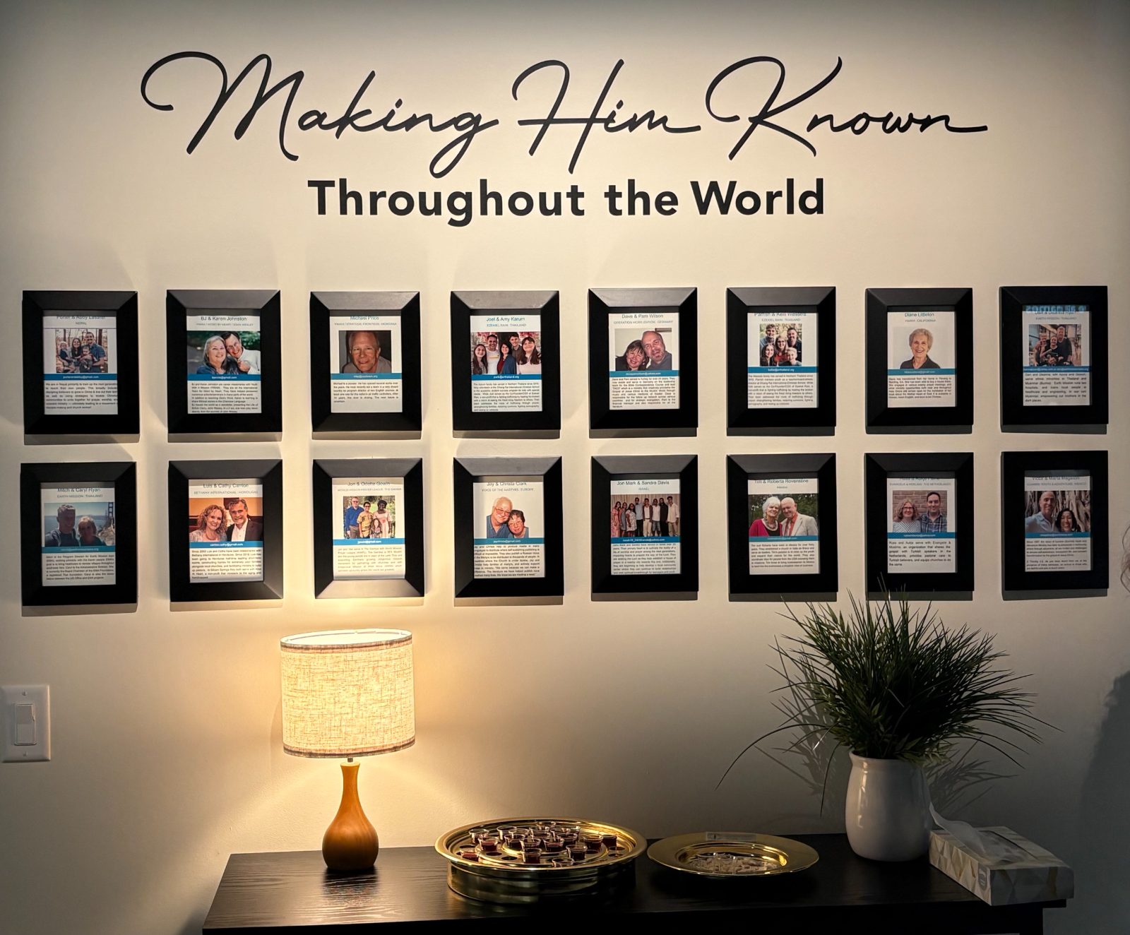 The missionary wall at Outreach Center Church — framed photos of supported missionary families under the words Making Him Known Throughout the World
