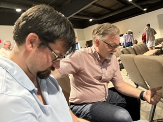Two men praying together after a service at Outreach Center Church